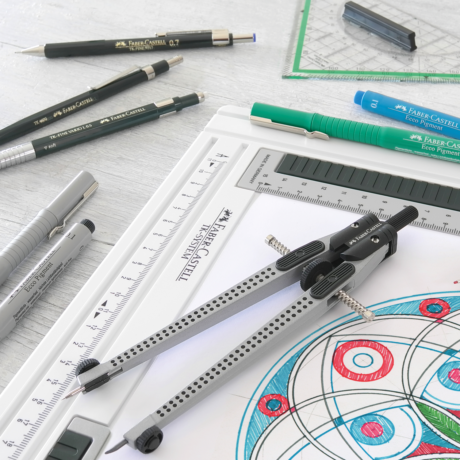 TK-Fine 9713 Druckbleistift von Faber Castell auf einem Schreibtisch mit Zeichenwerkzeugen und geometrischen Formen.