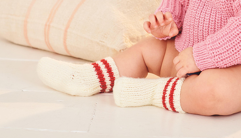 Strickanleitung für College-Babysocken aus Baby Classic dk zeigt weiche, warme Socken für Babys.