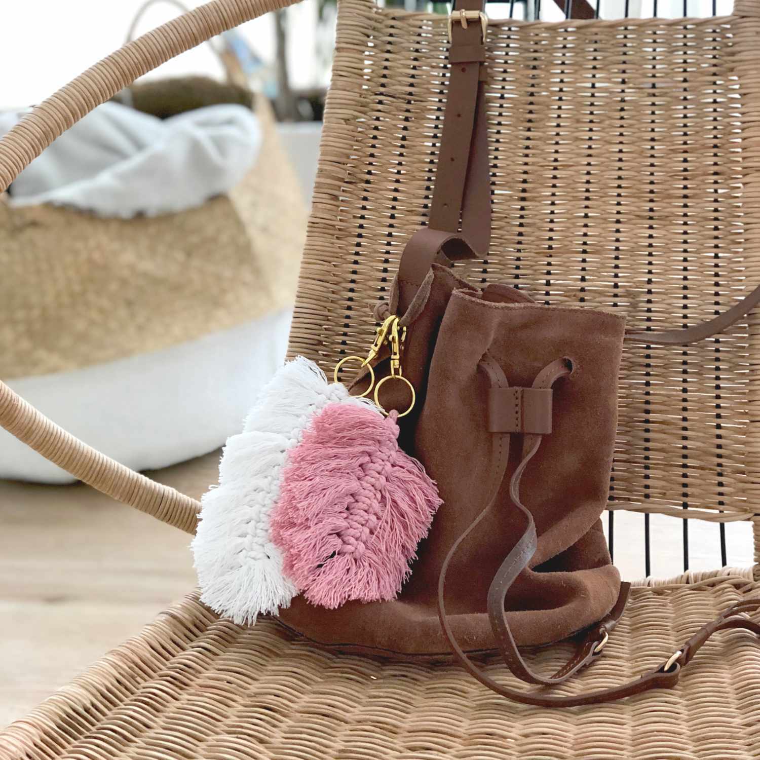 Baumwollkordel für Makramee 5mm 80m 500g: Handtasche mit Quasten in Weiß und Altrosa, dekorativ an einem Stuhl hängend.