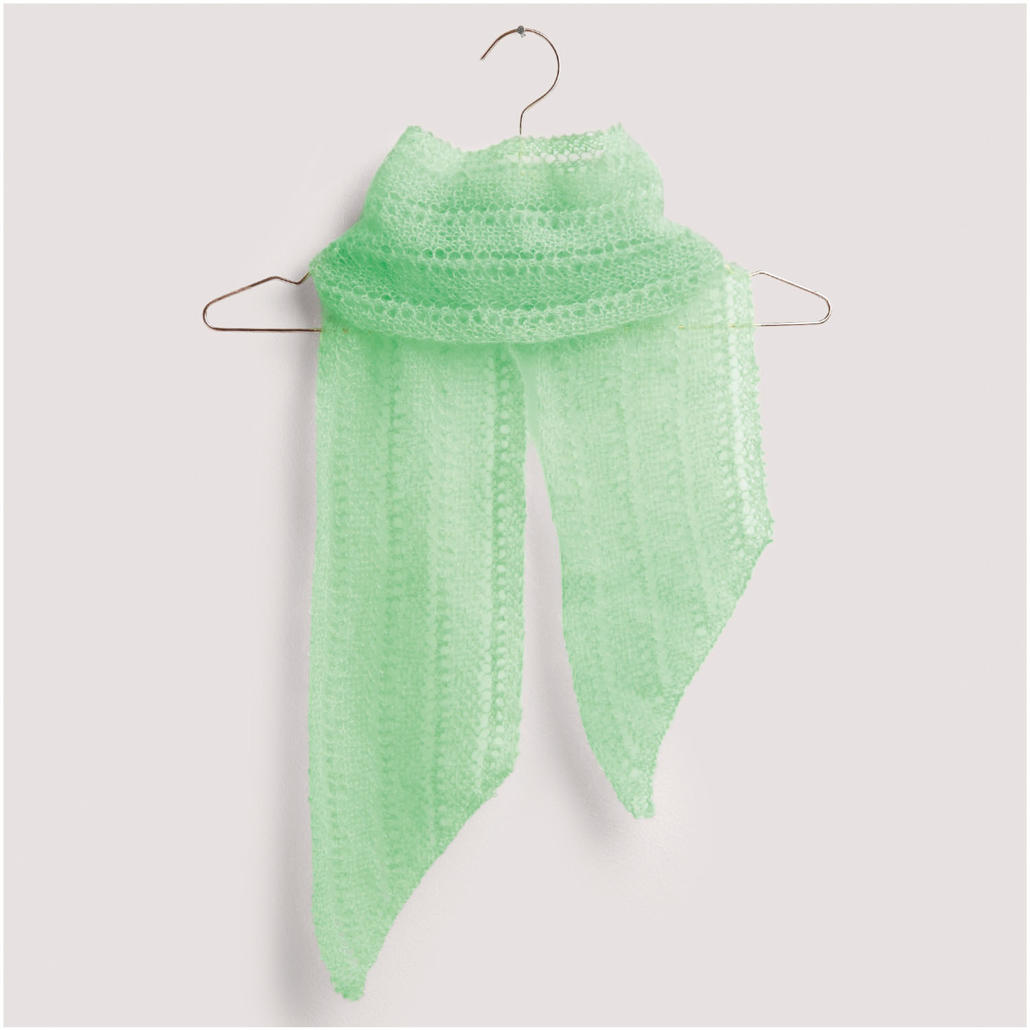 Strickset Tuch Modell 18 aus Die Neue Masche Nr. 8: Zartes, mintgrünes Tuch auf einem Kleiderbügel. Ideal für stilvolle Akzente.