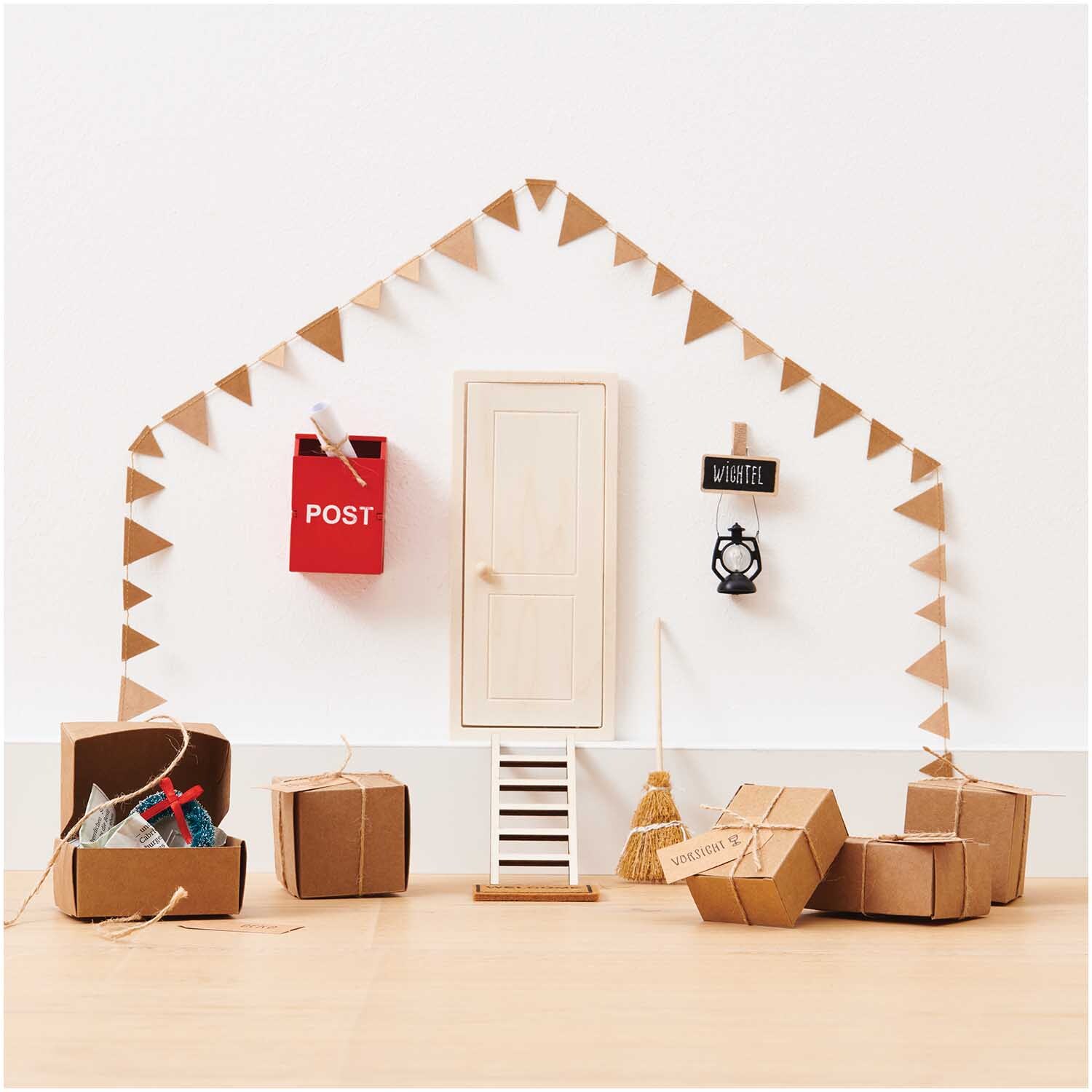Miniatur Geschenkschachteln 6 Stück von Rico Design in natürlichem Look, dekoriert vor einer kleinen Tür mit Postkasten und Wimpelgirlande.