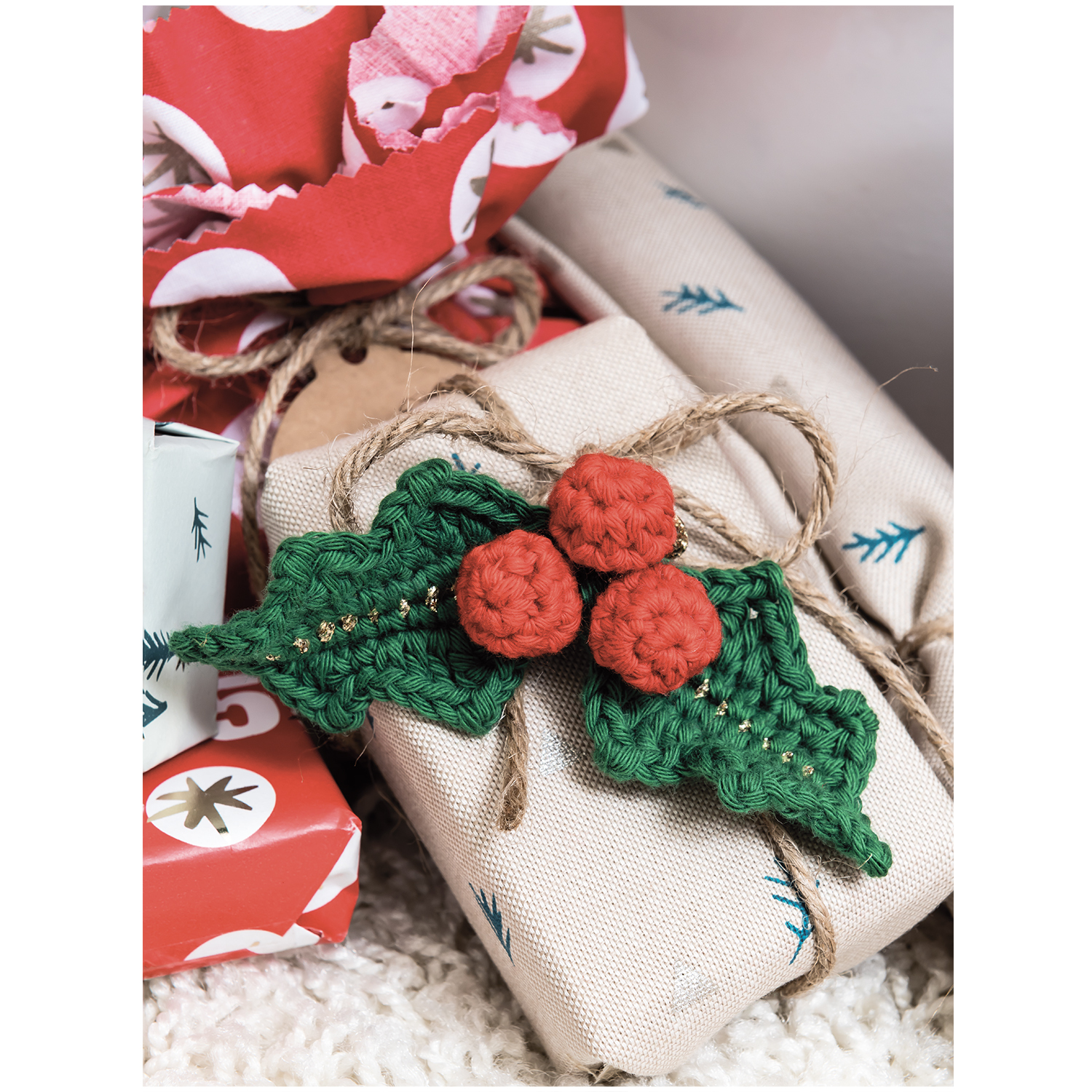 Creative Cotton aran Geschenkverpackung mit handgefertigtem, grünem und rotem Häkeldekor. Perfekt für festliche Anlässe.