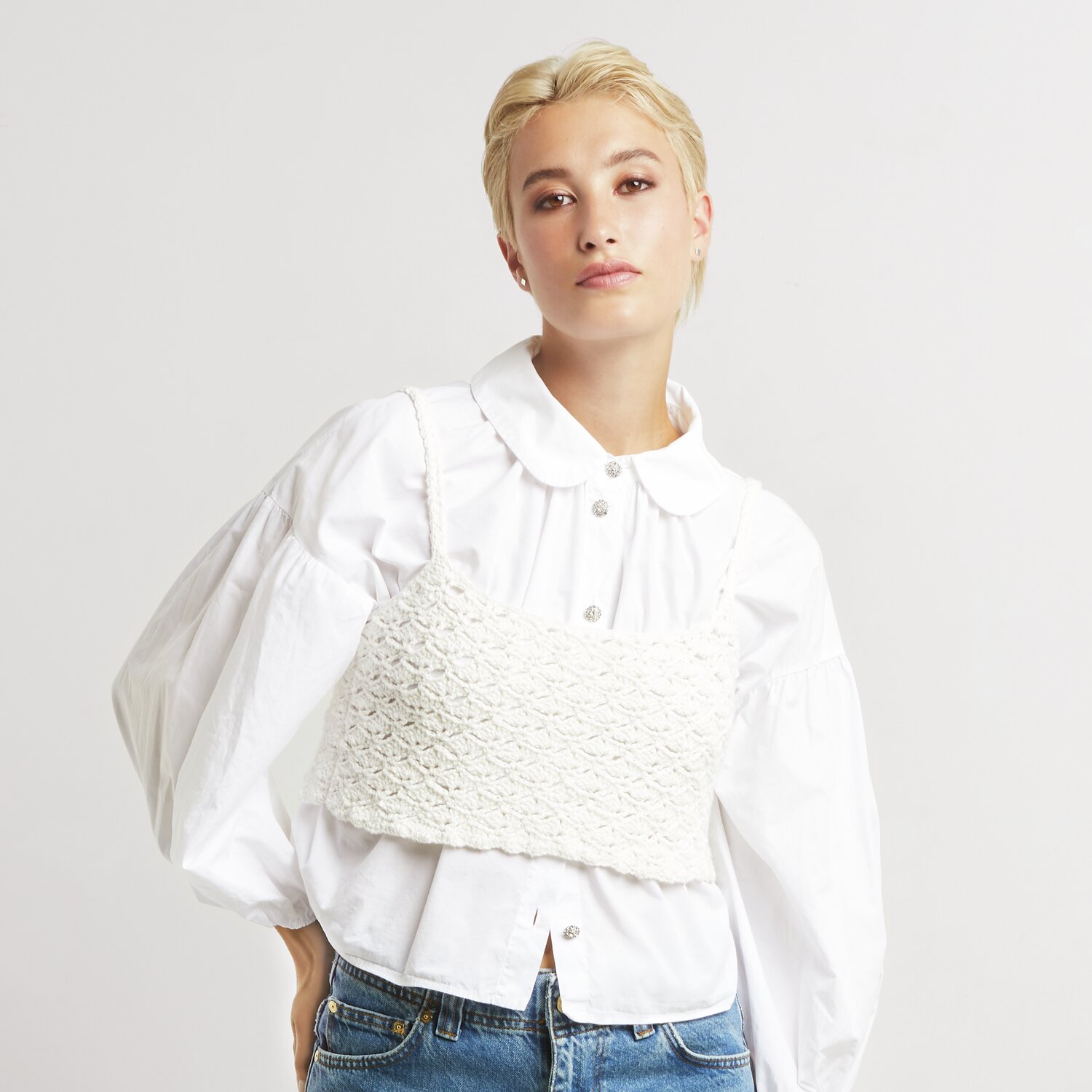 Made by Me No. 20 Frühjahr-Sommer: Frau trägt weißes, gestricktes Top von Rico Design über weißer Bluse.