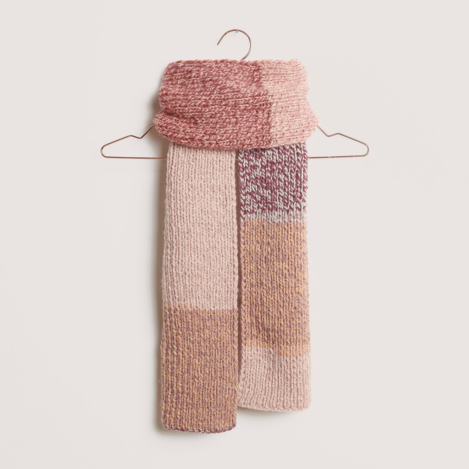 Peaches: Strickschal in Rosa- und Beigetönen, aufgehängt an einem Kleiderbügel. Creative Chic-Unique.