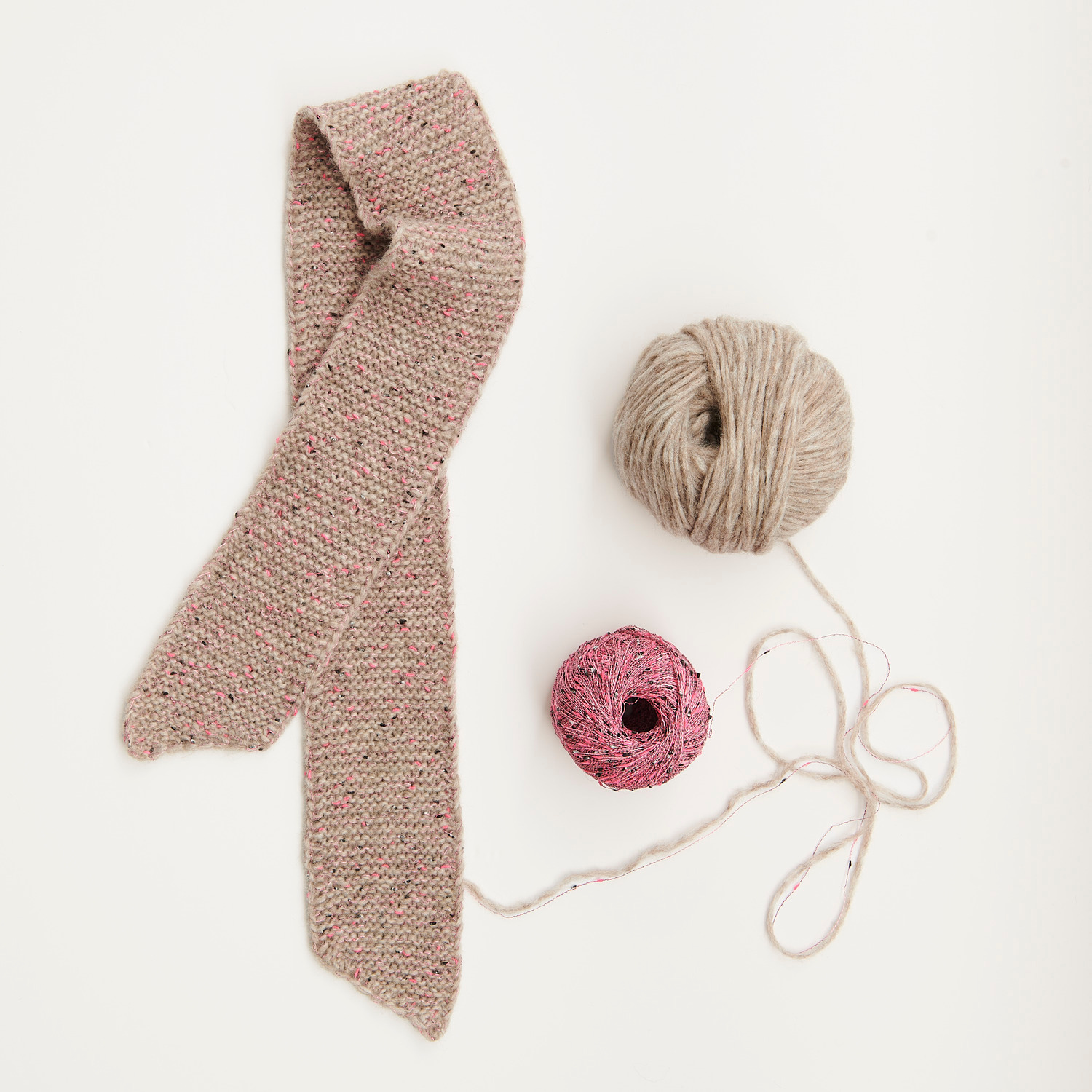 Mini Tücher Special: Strickschal in Beige mit zwei Wollknäueln von Rico Design auf weißem Hintergrund.