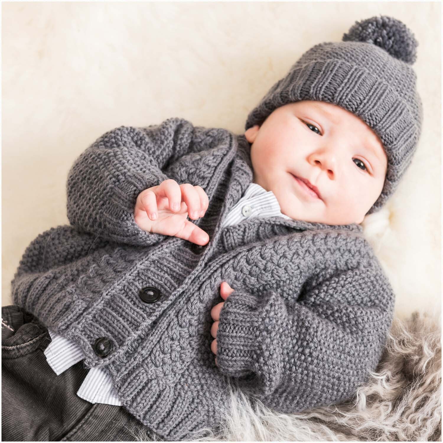 Rico Baby Dream dk uni - A Luxury Touch: Baby in gestrickter grauer Kleidung, weich und gemütlich, ideal für kühle Tage.