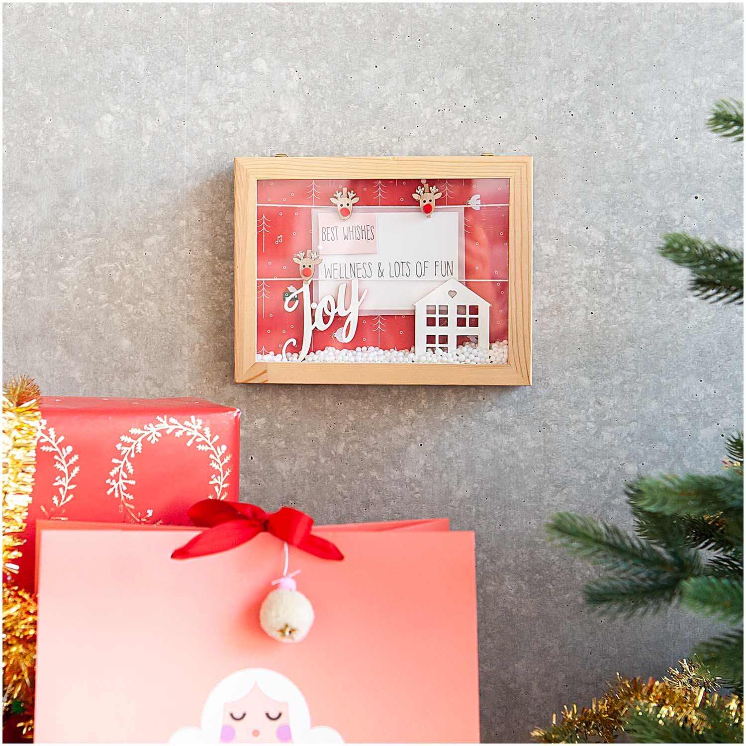 Holzdeko-Set Berglandschaft für XL-Dekohaube: Weihnachtliche Szene in Holzrahmen, umgeben von roten Geschenken und Tannenzweigen.
