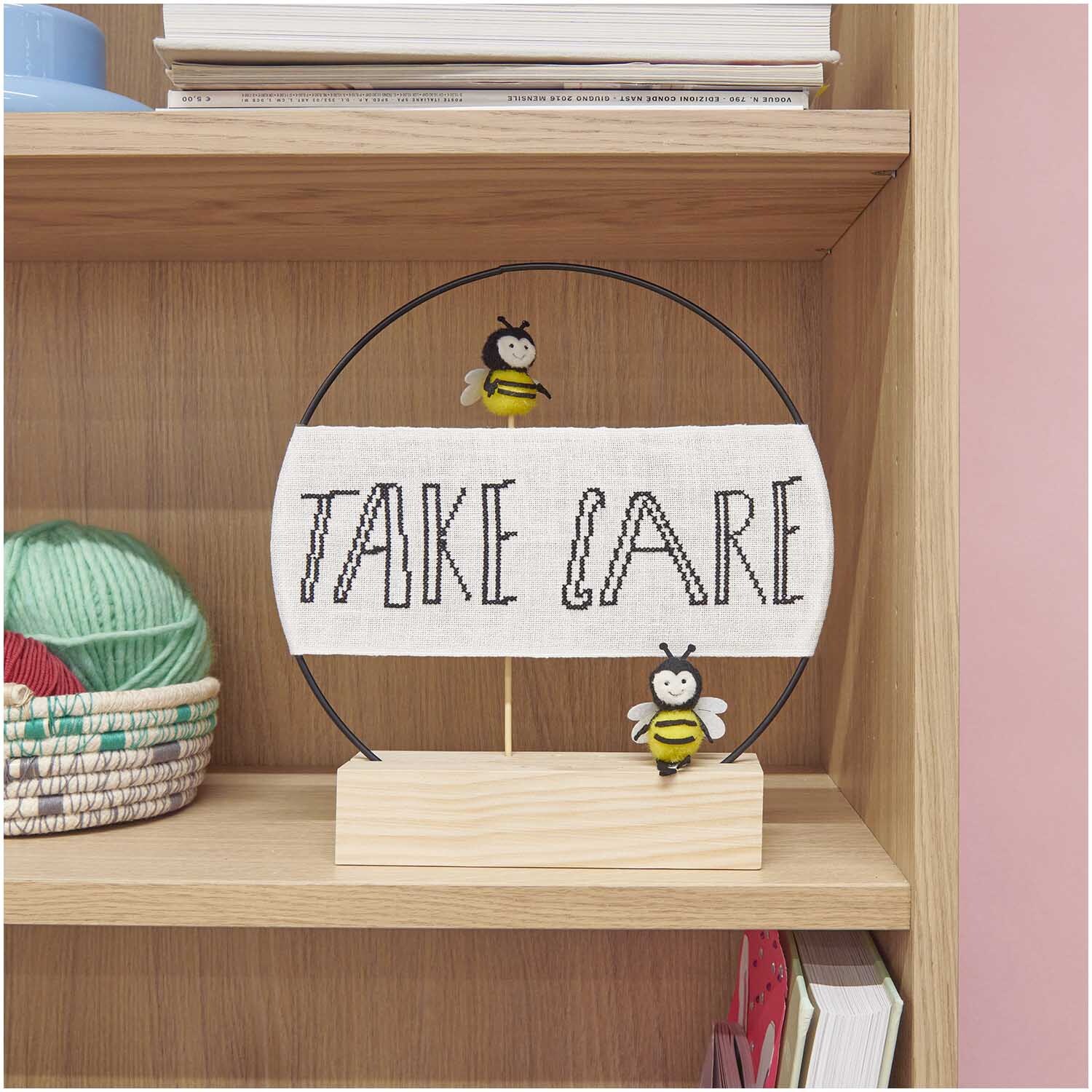 Deko-Stecker Biene 23cm von Rico Design: Zwei Bienen auf einem Holzsockel mit "Take Care"-Schild. Ideal für Regaldekoration.