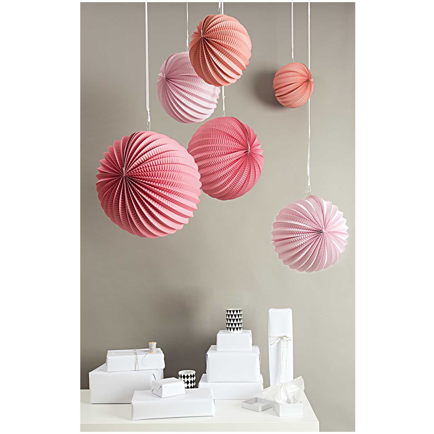 Lampions Sommer 3 Stück von Rico Design in Rosa hängen dekorativ über weißen Geschenkboxen.
