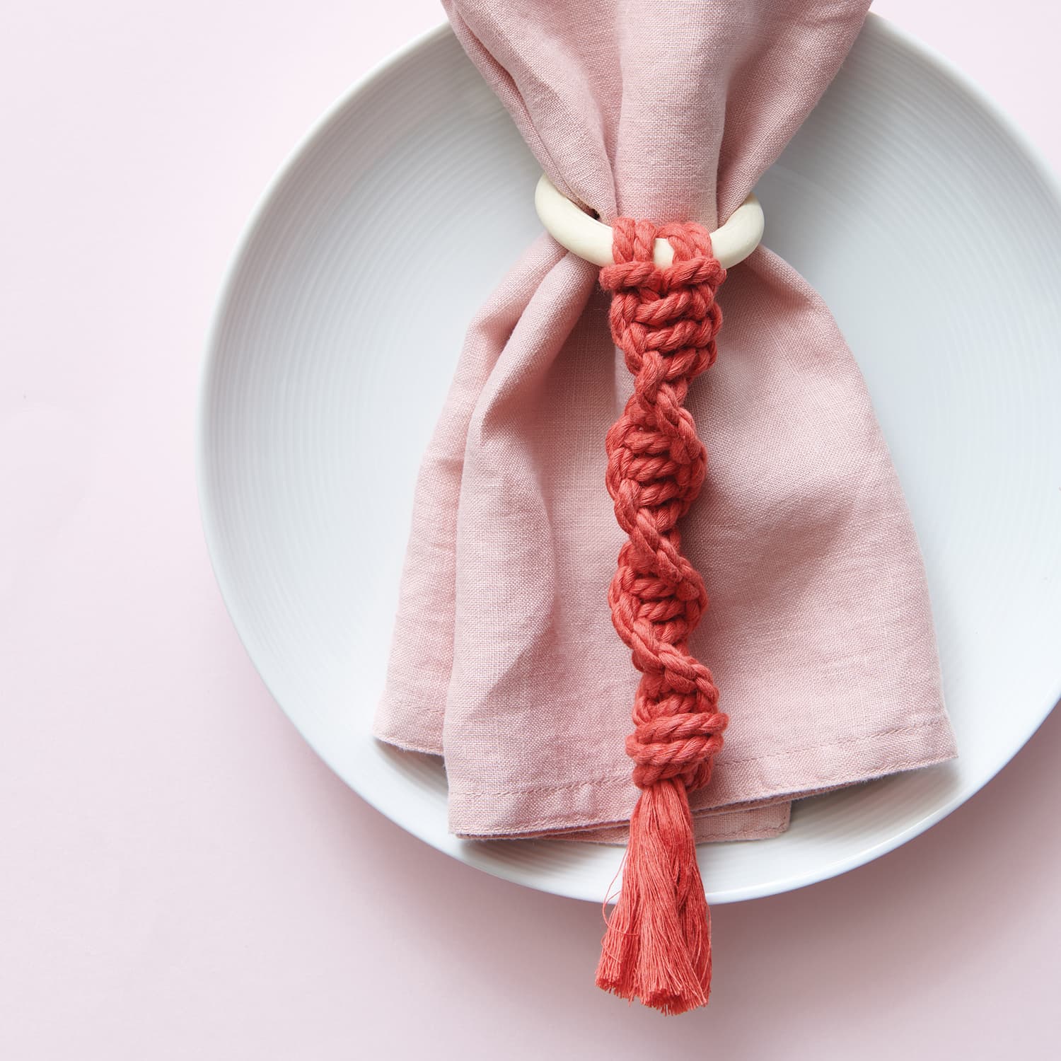 Makramee Dekoring aus rotem Garn arrangiert an Stoffserviette