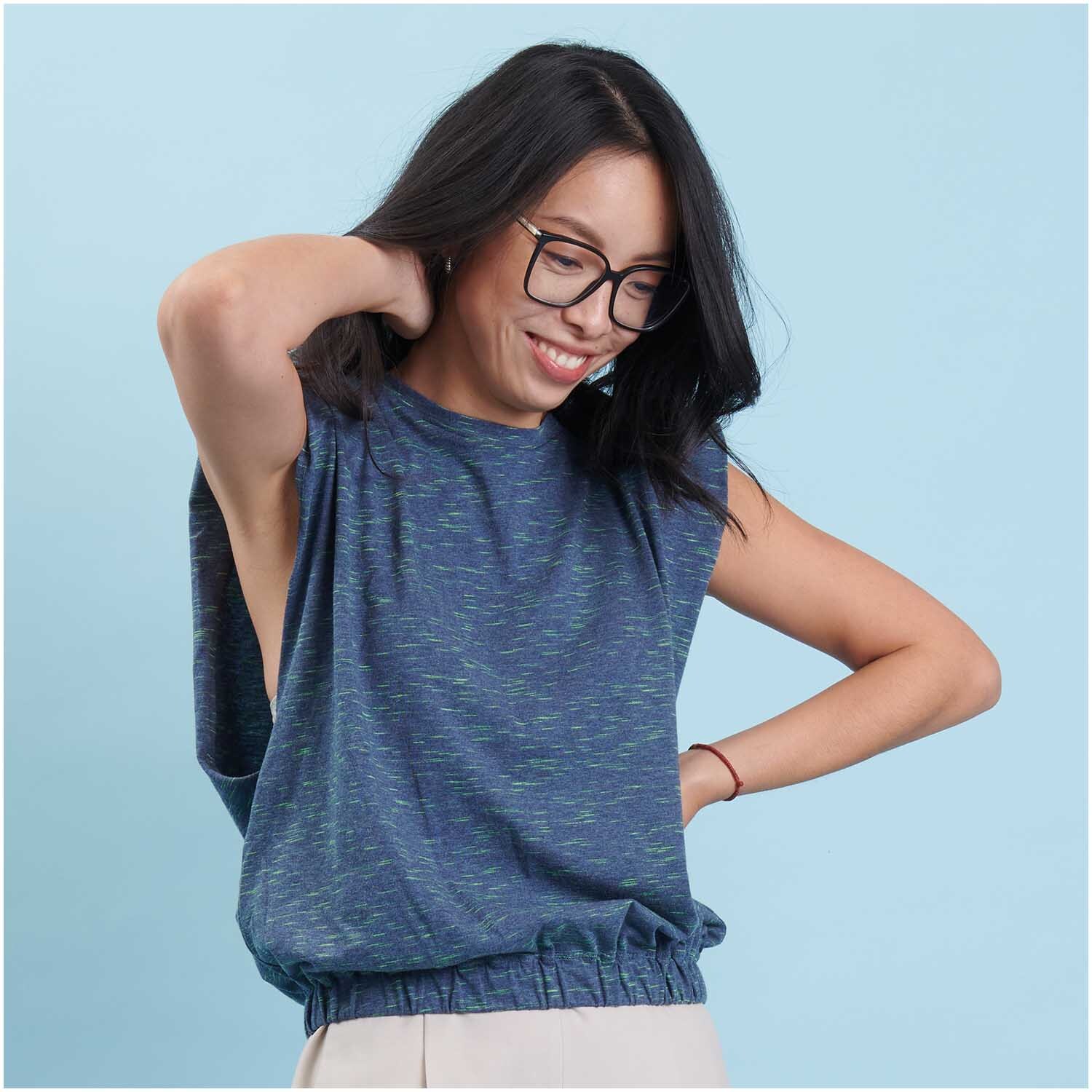 Stoffabschnitt Jersey in Blau und Grün von Rico Design, getragen von einer lächelnden Frau.