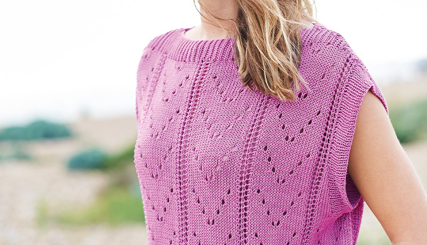 Strickanleitung Lochmuster-Top aus Essentials Cotton dk in Lila, getragen von einer Frau in natürlicher Umgebung.