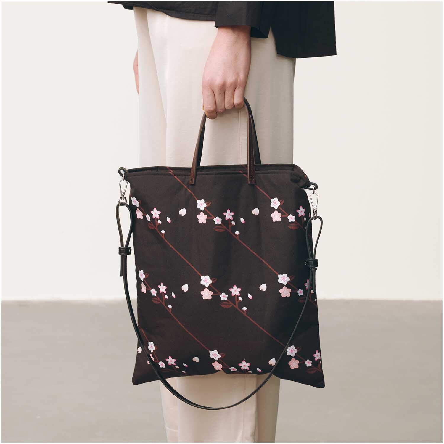 Kunstleder Schulterriemen kurz dunkelbraun-gold von Rico Design, getragen an einer Tasche mit Blumenmuster. Ideal für stilvolle Akzente.