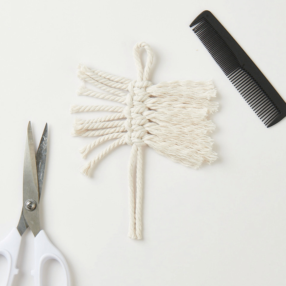 Makramee Set Blätter, 3 Stück: Weiße Makramee-Blätter mit Schere und Kamm auf hellem Hintergrund. Ideal für DIY-Projekte.
