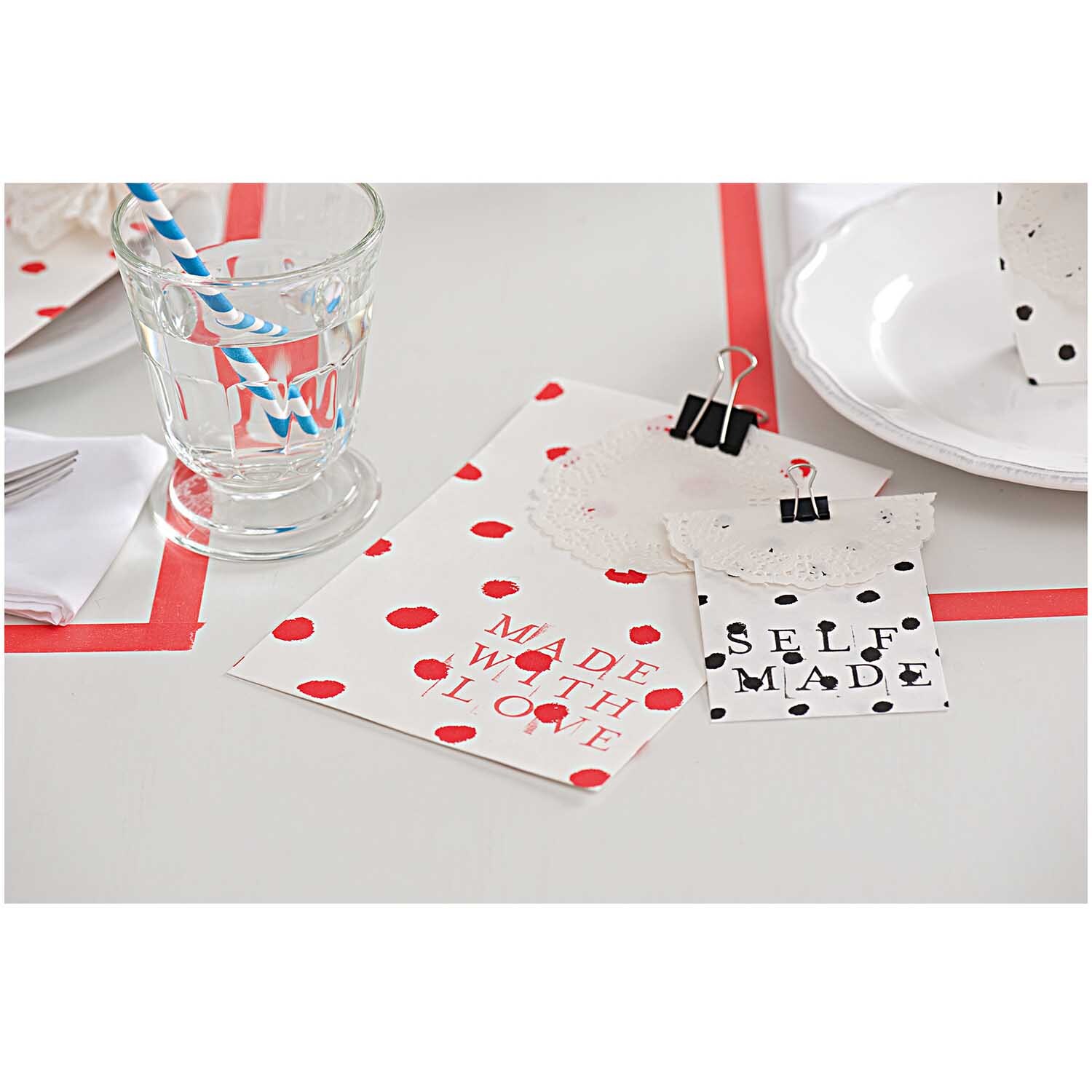 Paper Poetry Foldback Klammern halten stilvoll gepunktete Karten auf einem Tisch mit Glas und Strohhalm.
