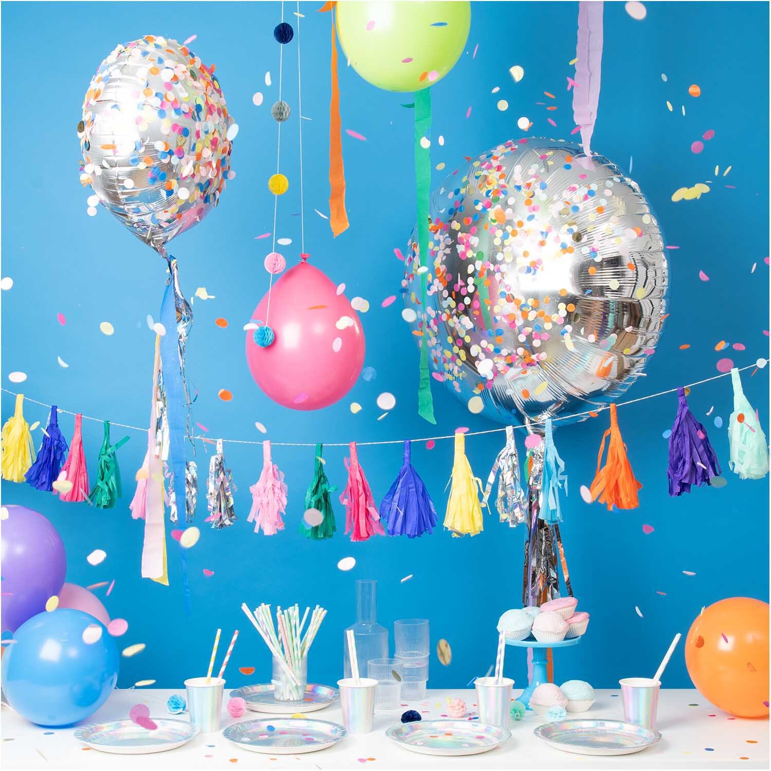 Paper Poetry Papierstrohhalme Mix sorbet 24 Stück vor einer bunten Partydekoration mit Luftballons und Konfetti.
