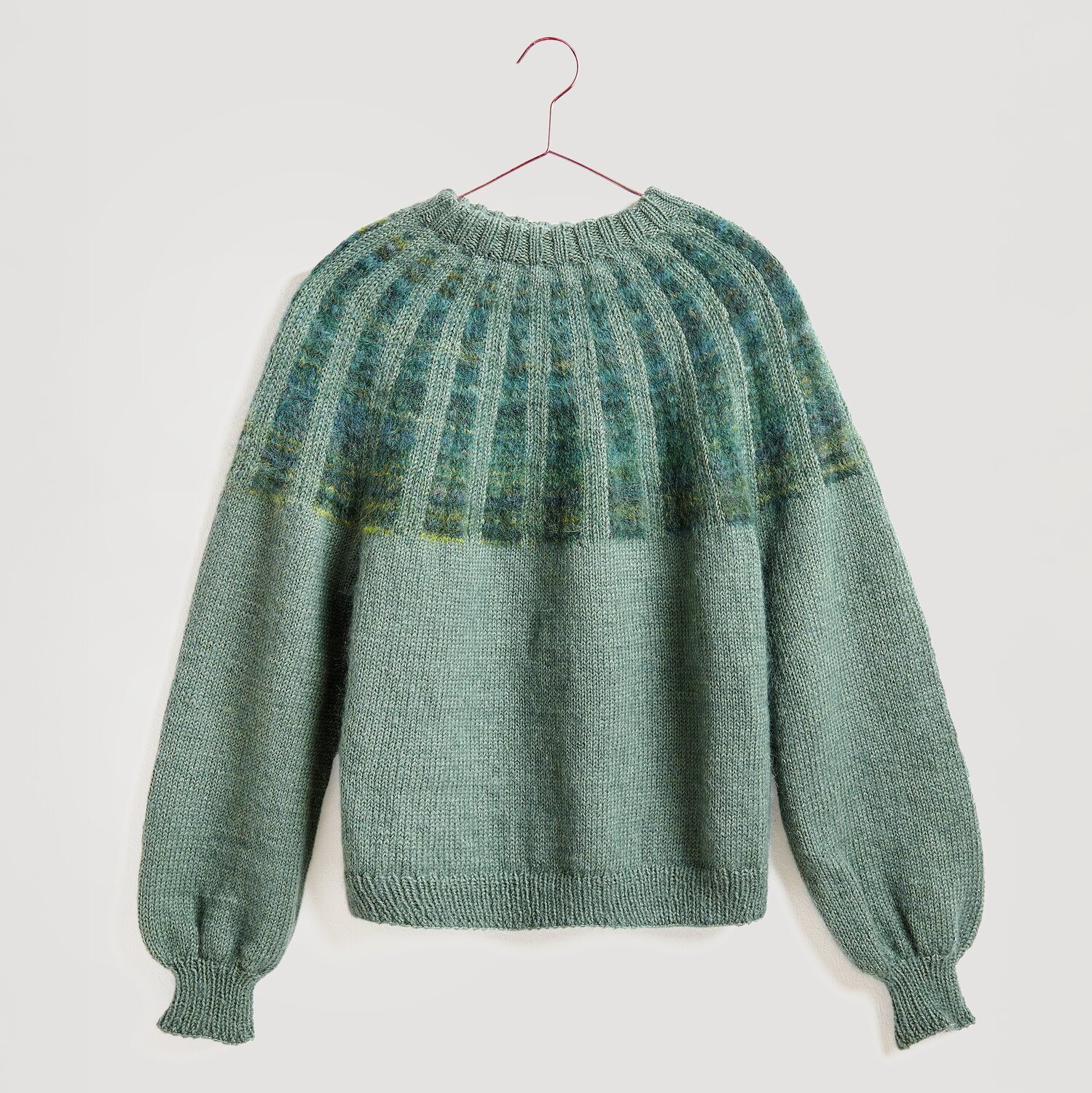 Gestrickter Pullover in grün auf Bügel