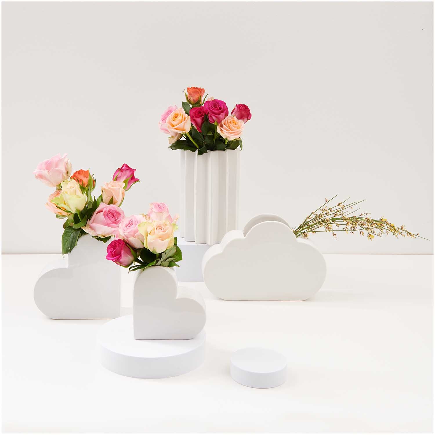 Keramik Vase Herz groß 16x6x16cm mit Blumenarrangement, umgeben von weiteren weißen Vasen und Dekorationen.