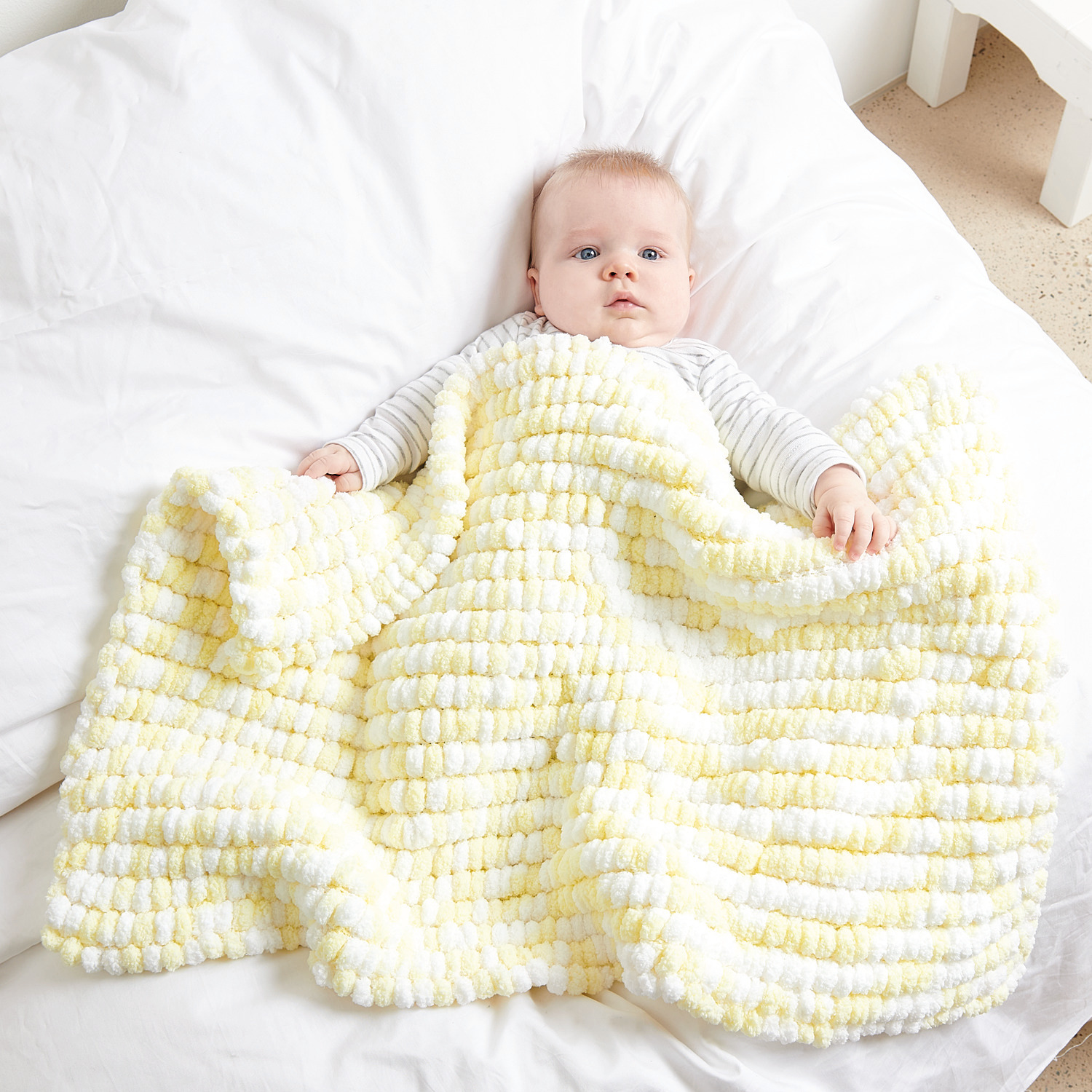 Creative Pompon Print: Baby in weicher, gestrickter Decke von Rico Design in Weiß-Zitrone, 200g.