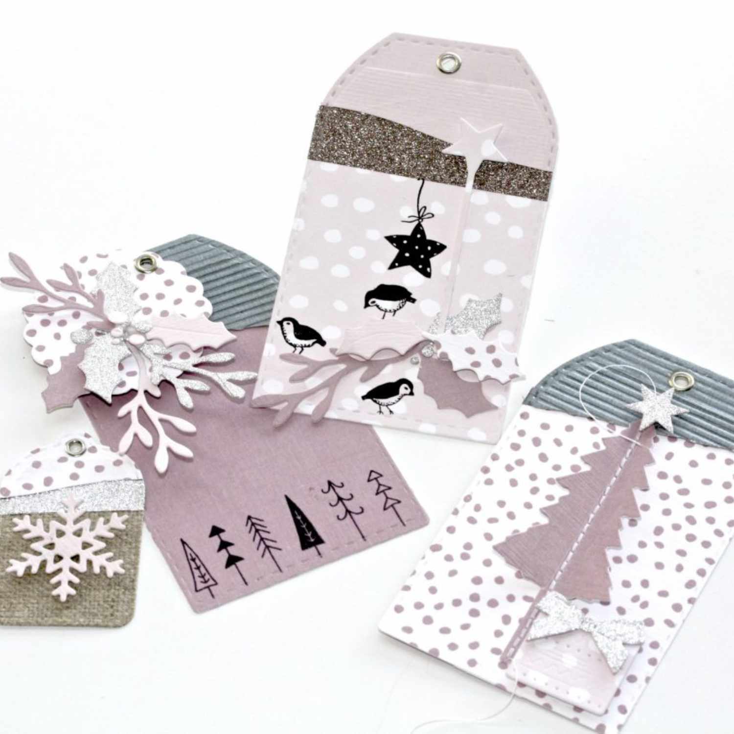 Framelits Die Anhänger von Sizzix zeigen dekorative, pastellfarbene Geschenkanhänger mit winterlichen Motiven und filigranen Details.