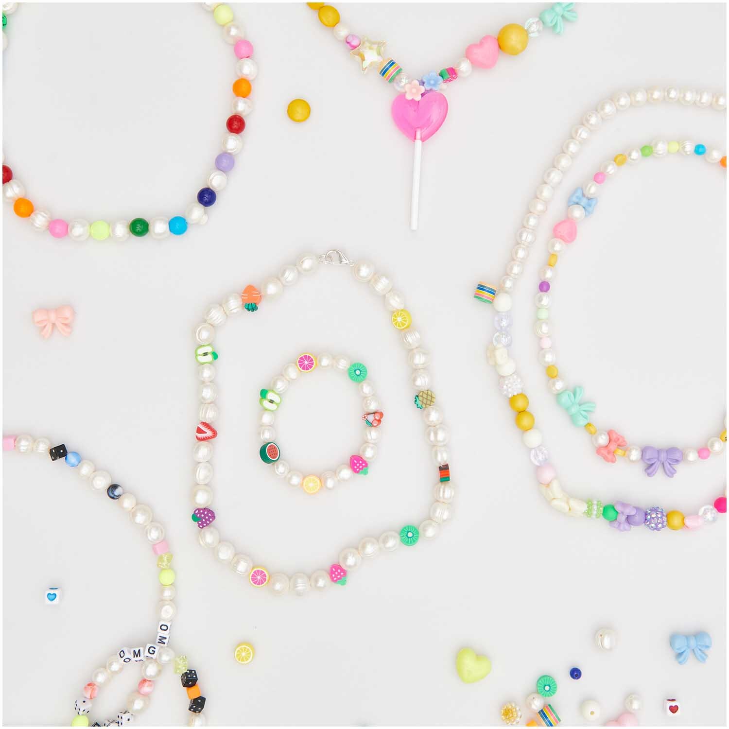 Itoshii Perlen rund irisierend 10mm 20 Stück von Rico Design, bunte Halsketten und Armbänder auf weißem Hintergrund.