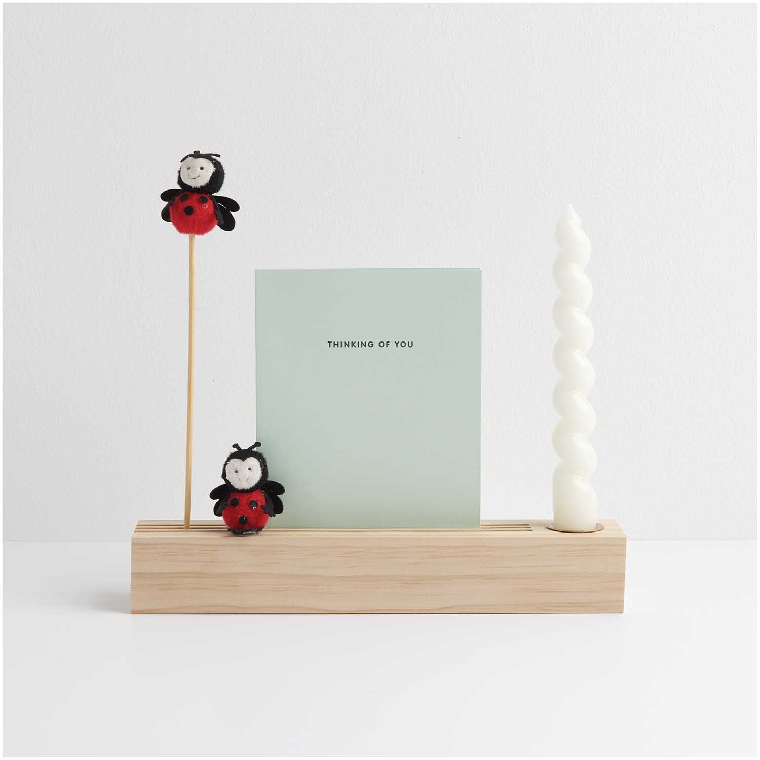 Deko-Stecker Marienkäfer 23cm von Rico Design in einem Holzständer mit Karte und weißer Kerze.