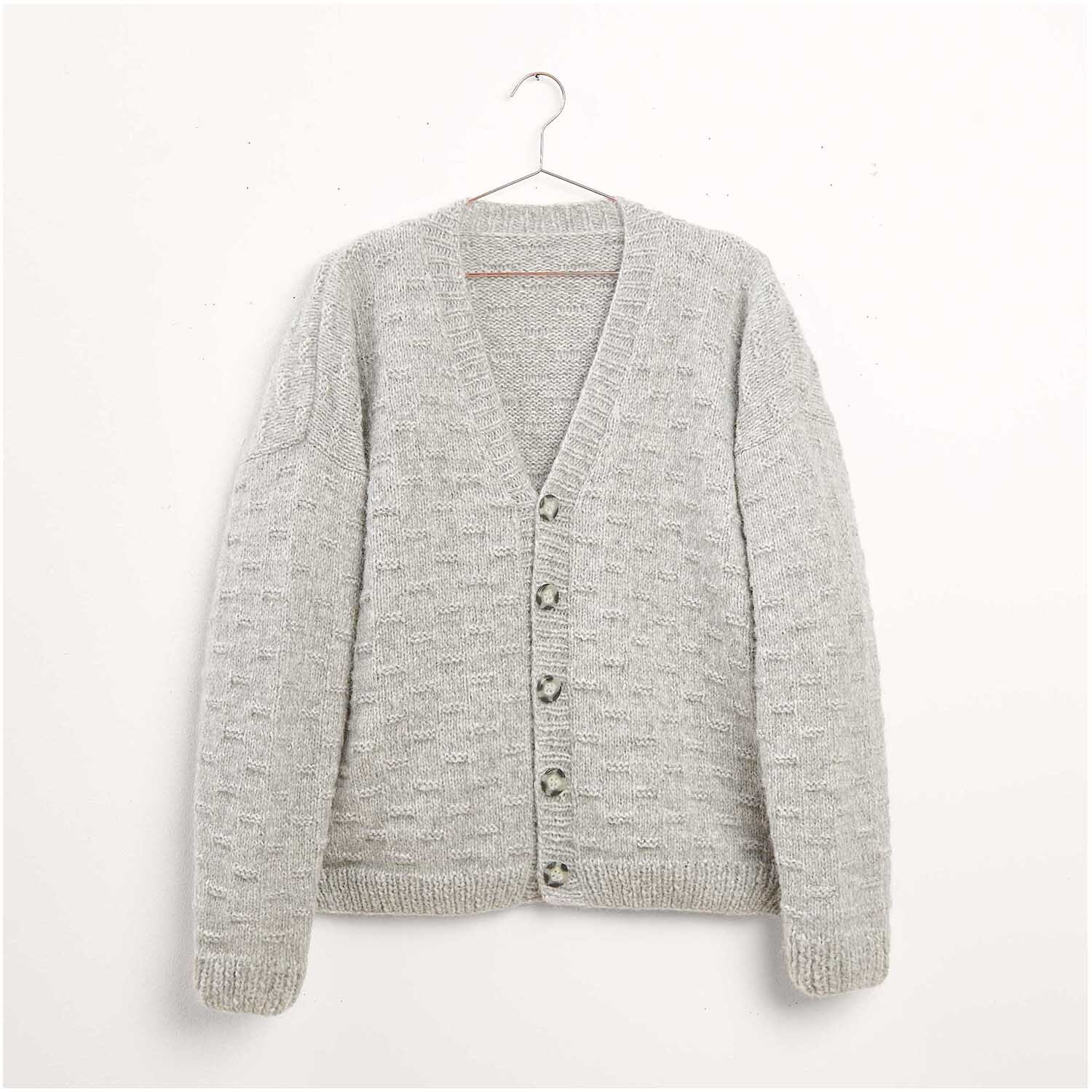 Strickset Cardigan Modell 23: Grauer Cardigan mit Knöpfen, hängend an einem Kleiderbügel. Ideal für Wintermode.