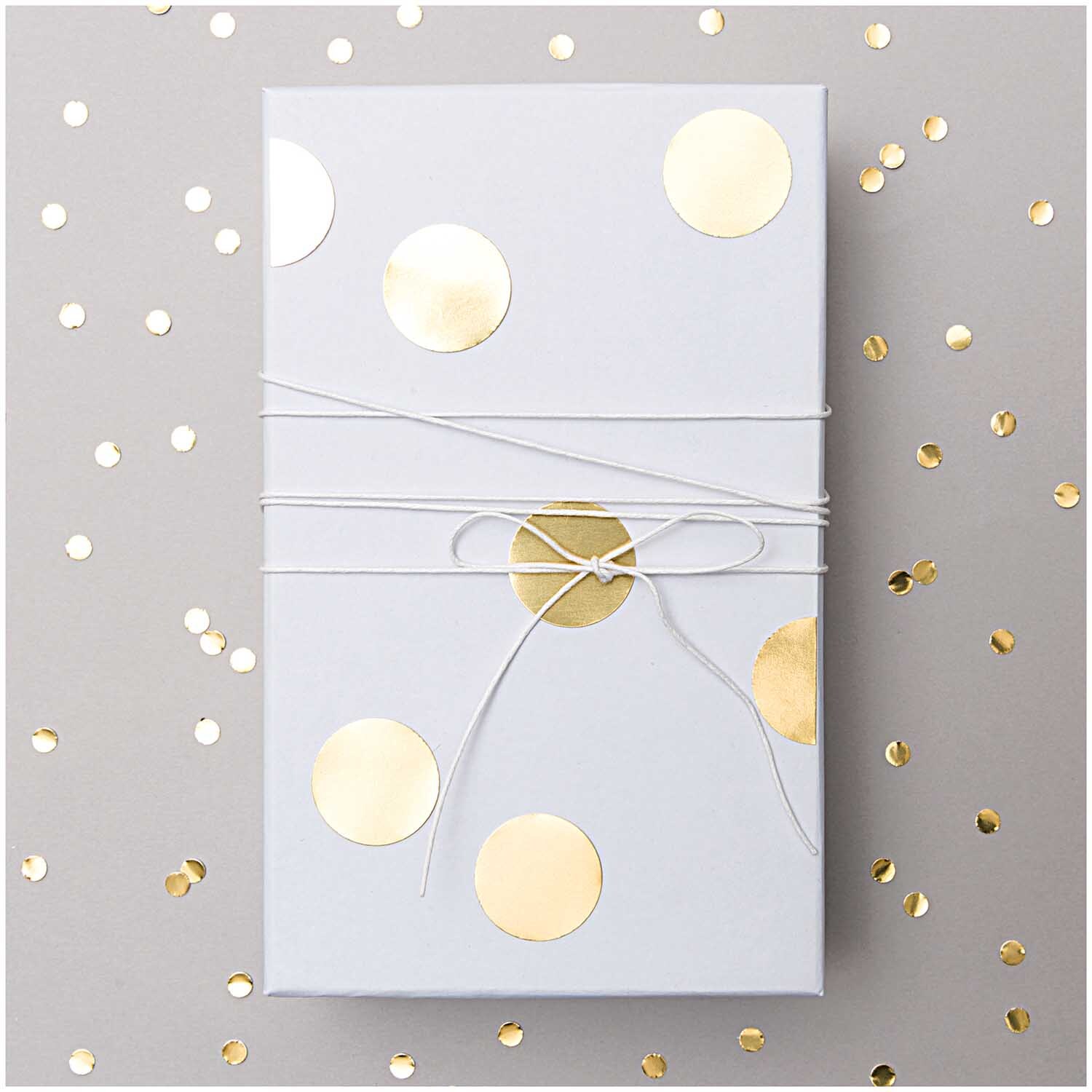 Paper Poetry Sticker Punkte gold 15mm 4 Bogen auf Geschenkverpackung mit goldenen Punkten dekoriert.