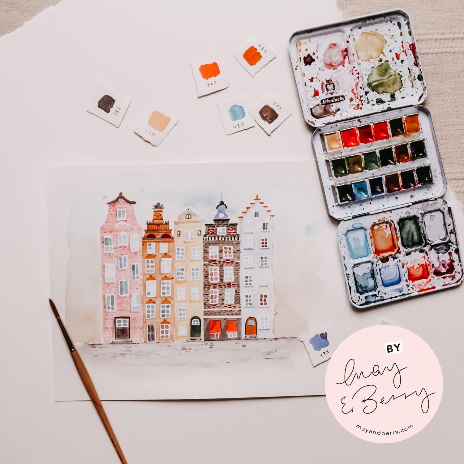 Anleitung Urban Watercoloring zeigt ein Aquarell von Stadthäusern mit Farbmischpalette und Pinsel.