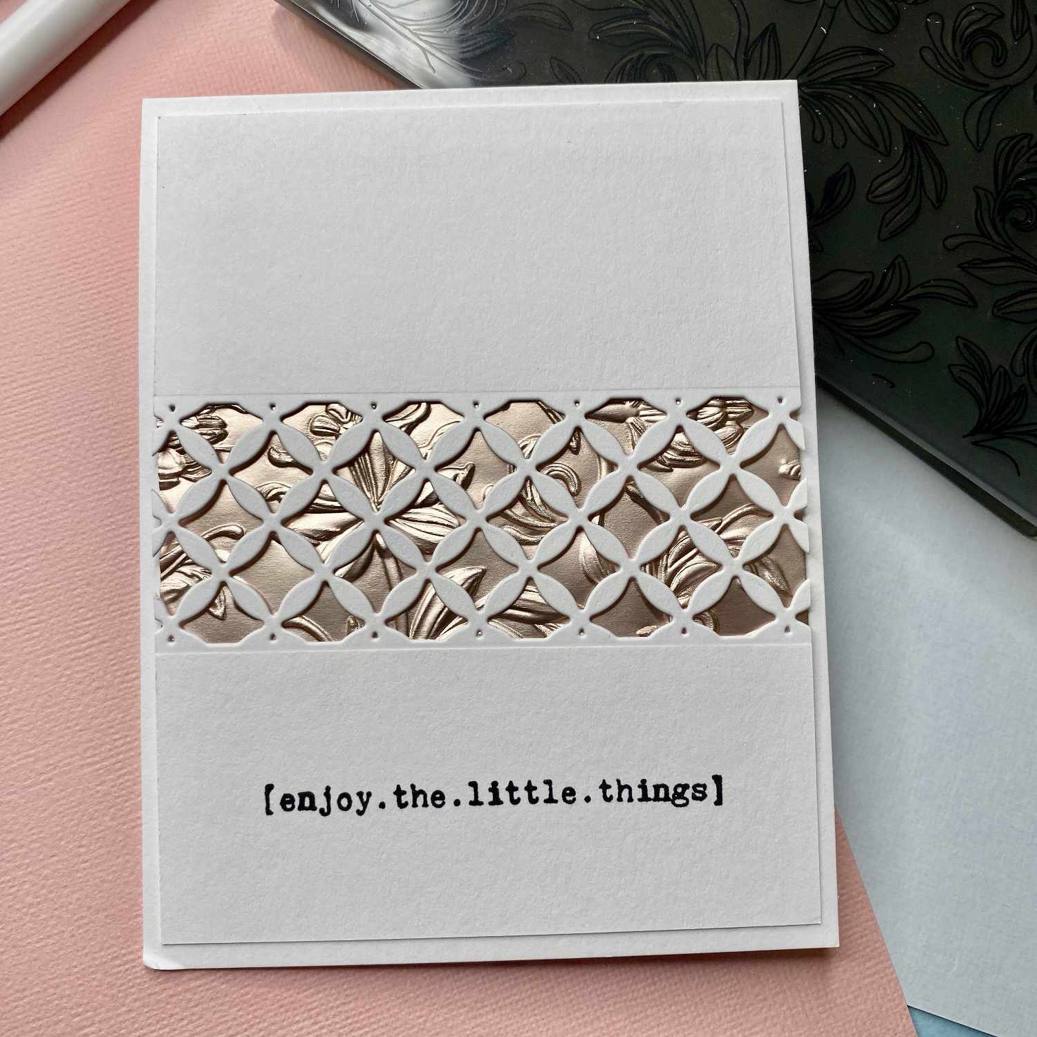 3D Textured Fades Embossing Folder Botanical von Sizzix: Weiße Karte mit geprägtem, botanischem Muster und dem Text "enjoy.the.little.things".
