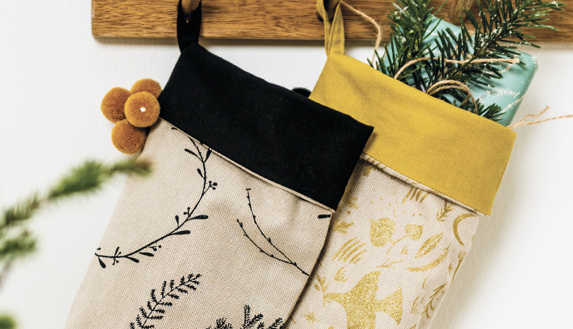 Nähanleitung Nikolaus-Stiefel: Zwei dekorative Stiefel mit floralen Mustern, gefüllt mit Tannenzweigen.