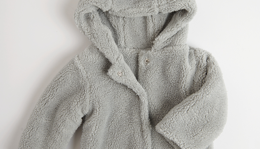 Nähanleitung Teddyjacke für Kinder: Flauschige, graue Jacke mit Kapuze, ideal für kalte Tage.