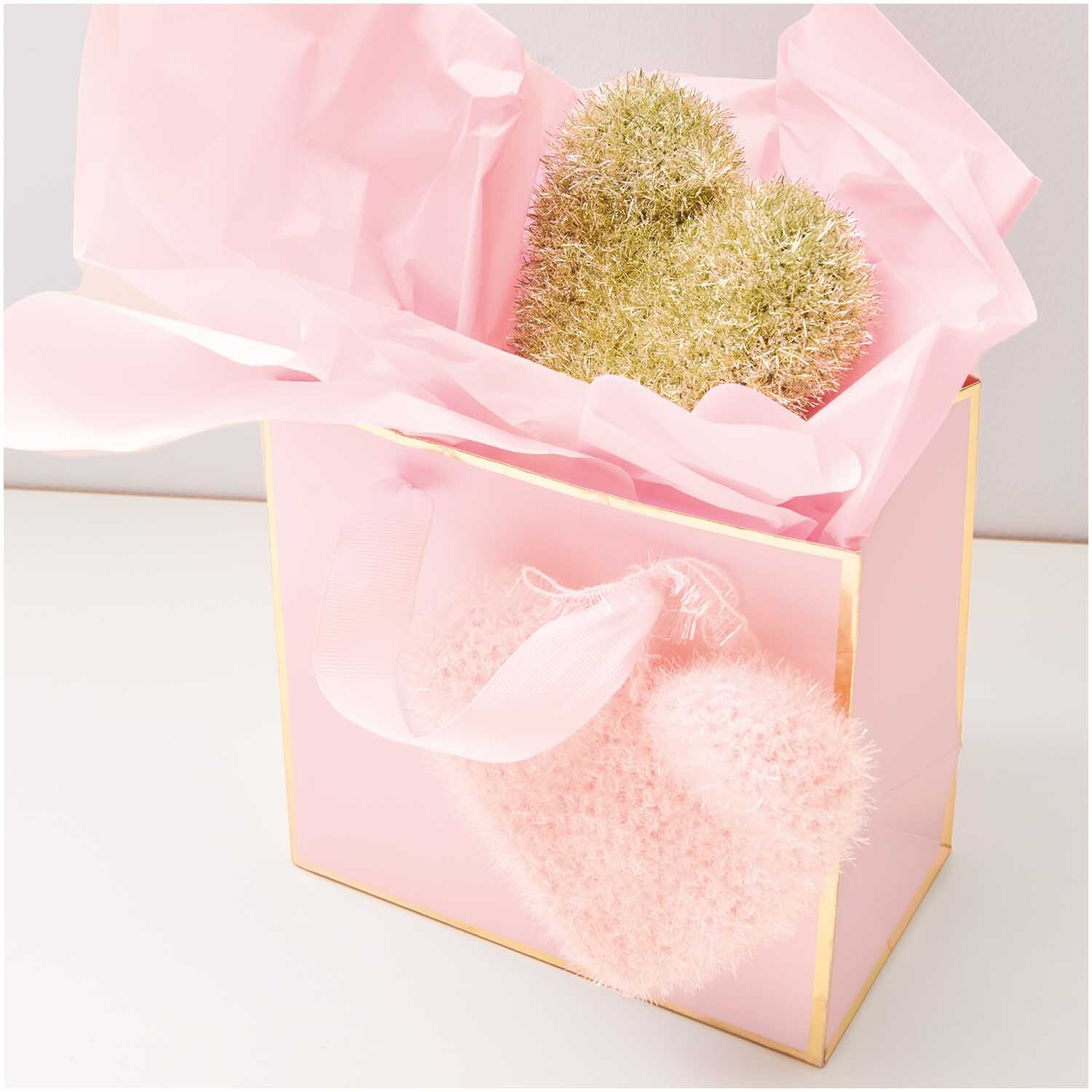 Creative Bubble von Rico Design in einer rosa Geschenkbox mit goldenen und rosa Strickherzen.