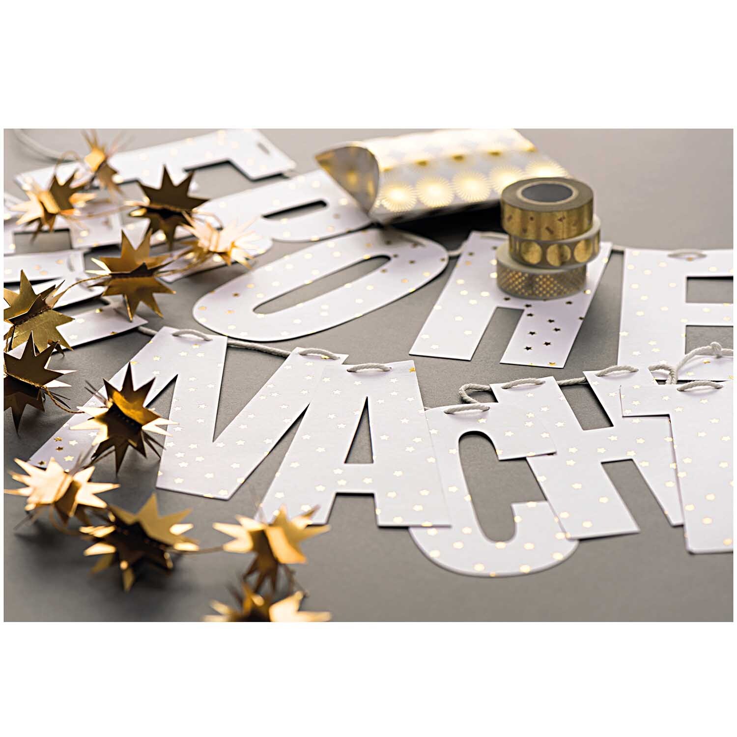 Paper Poetry Girlande Sterne 1,3m Hot Foil zeigt goldene Sterne und Buchstaben auf grauem Hintergrund. Ideal für festliche Dekorationen.