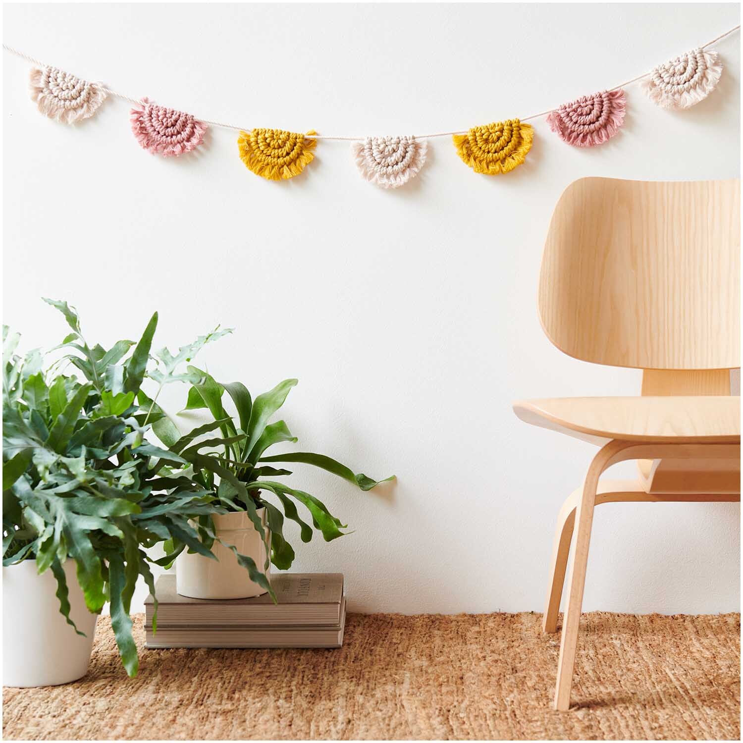 Creative Cotton Cord Makramee-Garn von Rico Design in einer gemütlichen Wohnszene mit Pflanzen und Holzstuhl.