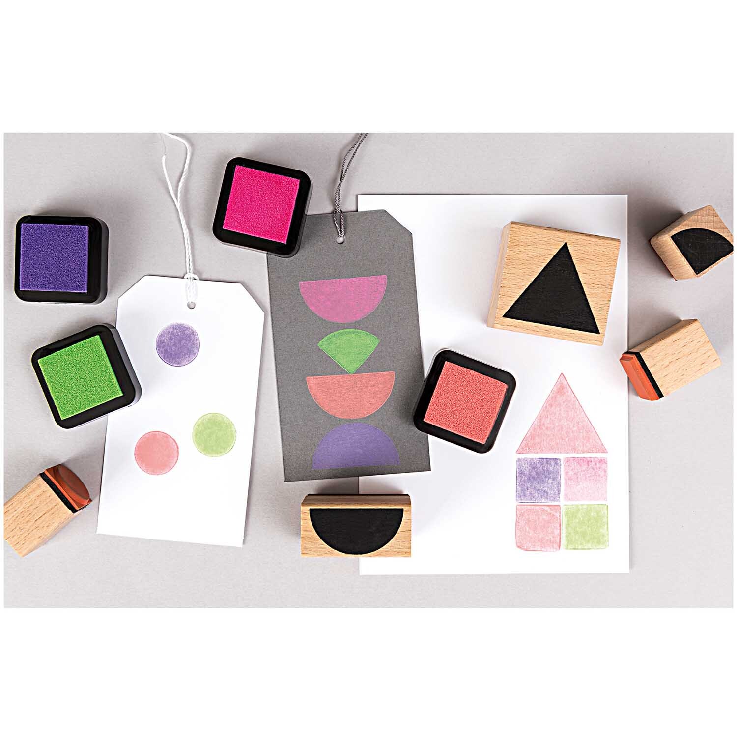 Paper Poetry Stempelset geometrische Symbole eckig zeigt bunte Stempelkissen und Holzstempel mit Formen. Ideal für kreative Projekte.