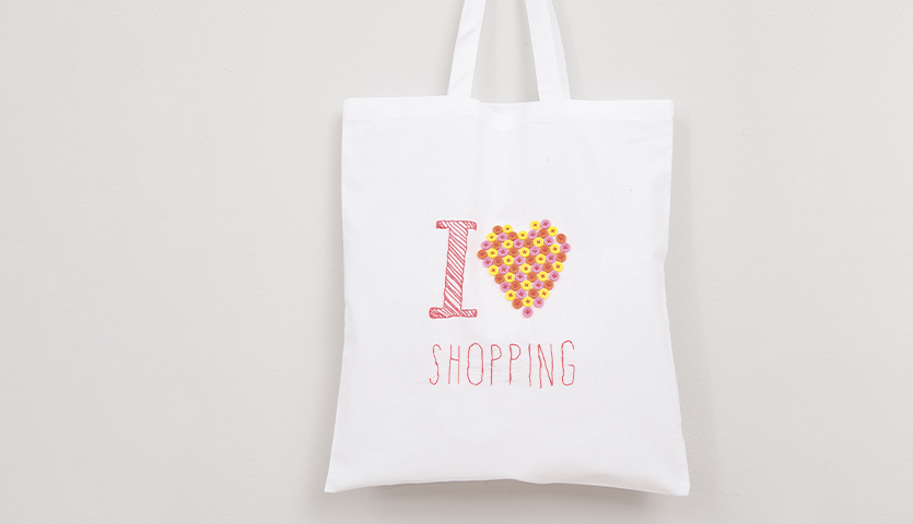 Stickanleitung Tragetasche mit "I Love Shopping"-Design, Herz aus Blumen, auf weißem Hintergrund.