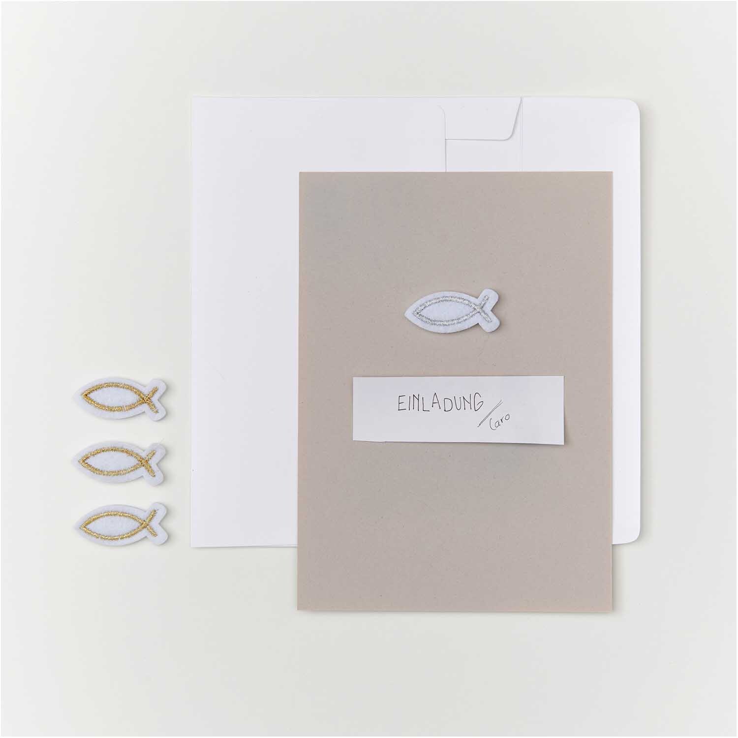 Filzstreu Fisch weiß-gold 12 Stück: Einladungskarte mit Fischmotiv und Umschlag, ideal für festliche Anlässe.