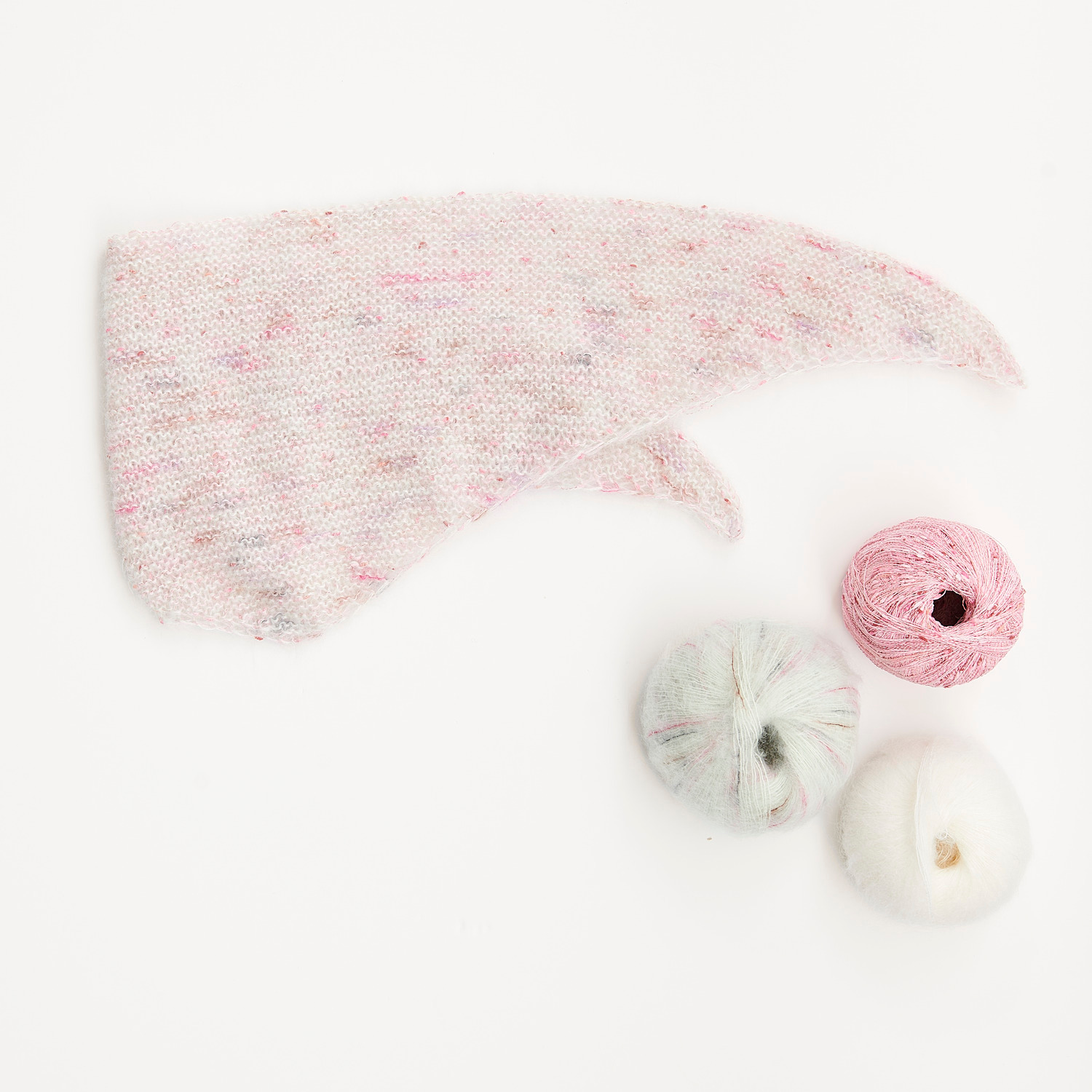 Mini Tücher Special: Ein gestricktes Tuch in Pastellfarben mit drei Wollknäueln in Rosa, Weiß und Creme. Ideal für kreative Projekte.