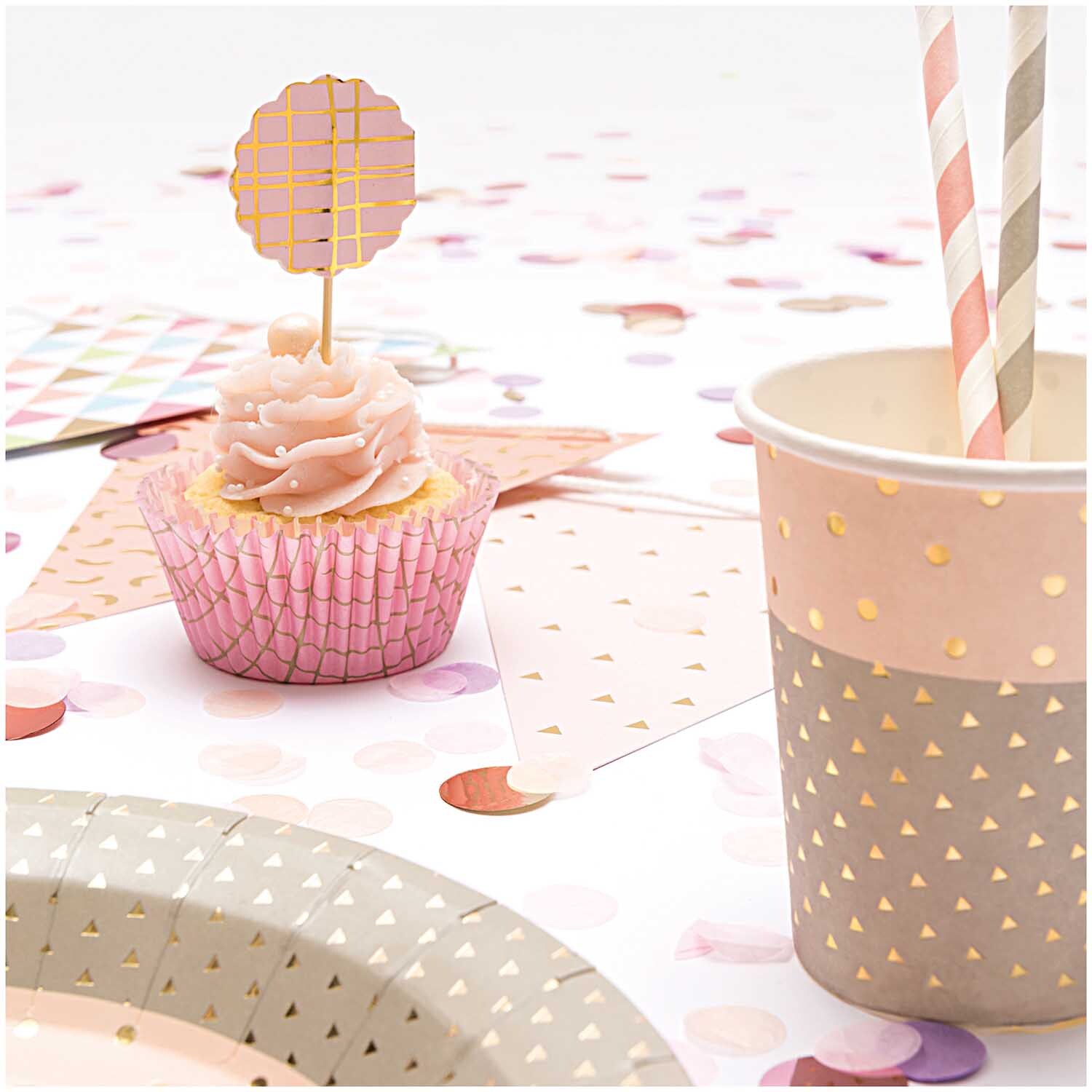 Paper Poetry Girlande Wimpel dekoriert einen Tisch mit pastellfarbenen Partyartikeln und einem Cupcake.