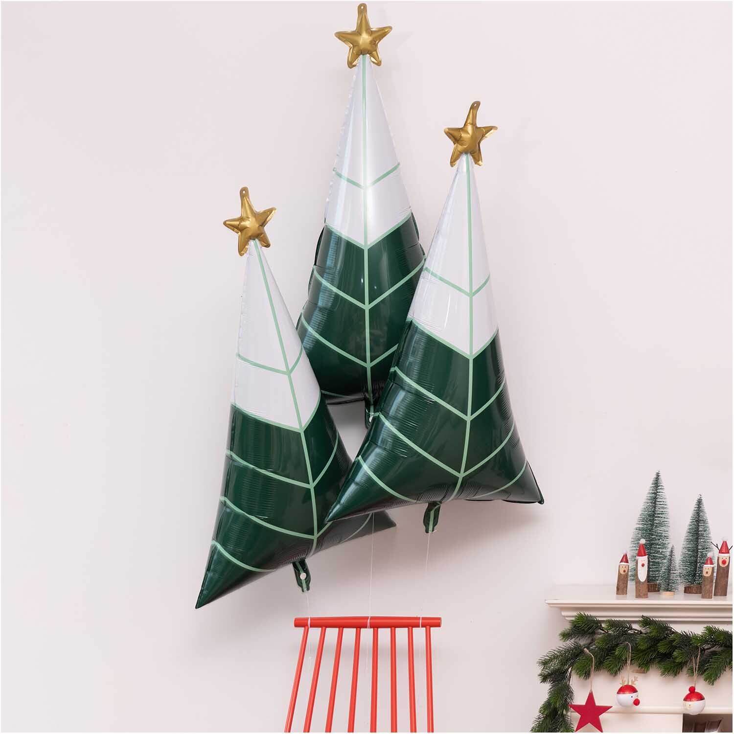 Folienballon Tannenbaum 65x110cm von Rico Design: Drei grüne Ballons in Tannenbaumform mit goldenen Sternen, festlich dekoriert.