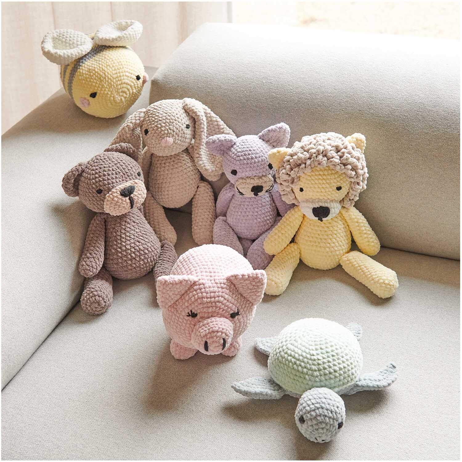 Creative Chenillove: Kuscheltiere aus weichem Garn in verschiedenen Pastellfarben auf einem Sofa. Ideal für Kinderzimmer.