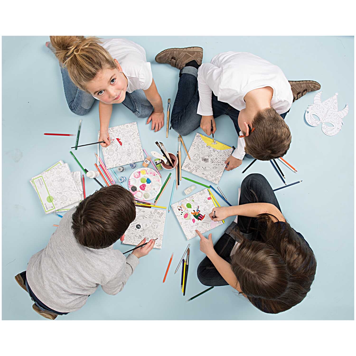 DIY Set Ausmalen für Kinder: Kinder malen mit Buntstiften auf Papier, umgeben von Malutensilien.