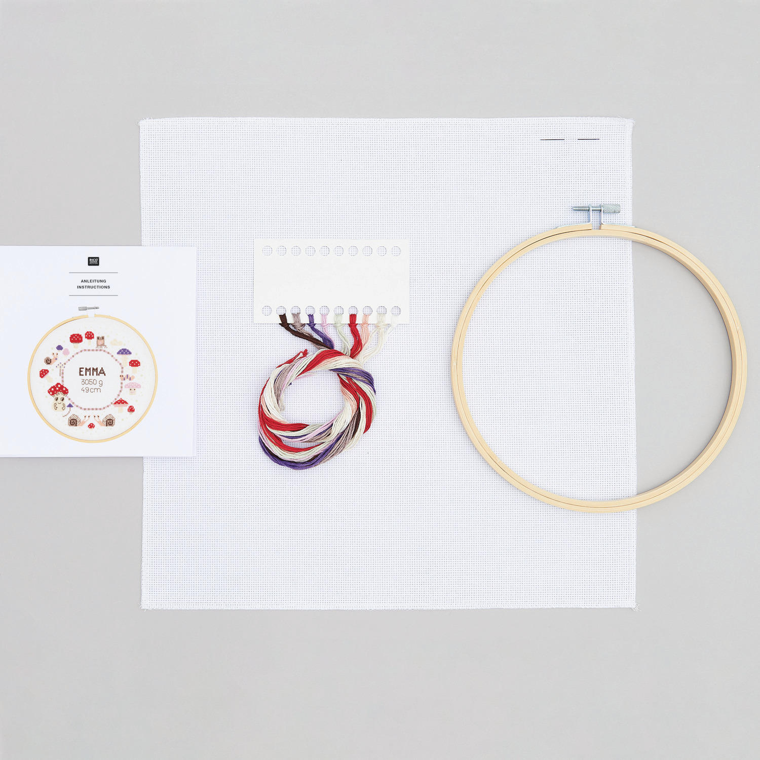 Stickpackung Geburtsbild Shrooom mit Stickrahmen, Garn in Rot- und Blautönen und weißem Stoff von Rico Design. Ideal für kreative Handarbeiten.