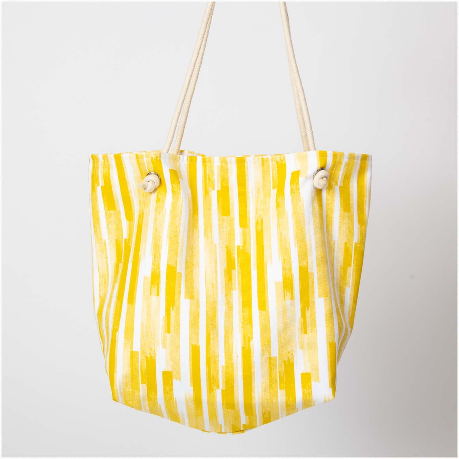 Druckstoff Canvas Aloha Streifen weiß-gelb 140cm: Gelb-weiß gestreifte Tasche aus Canvas mit robusten Tragegriffen, ideal für den Sommer.