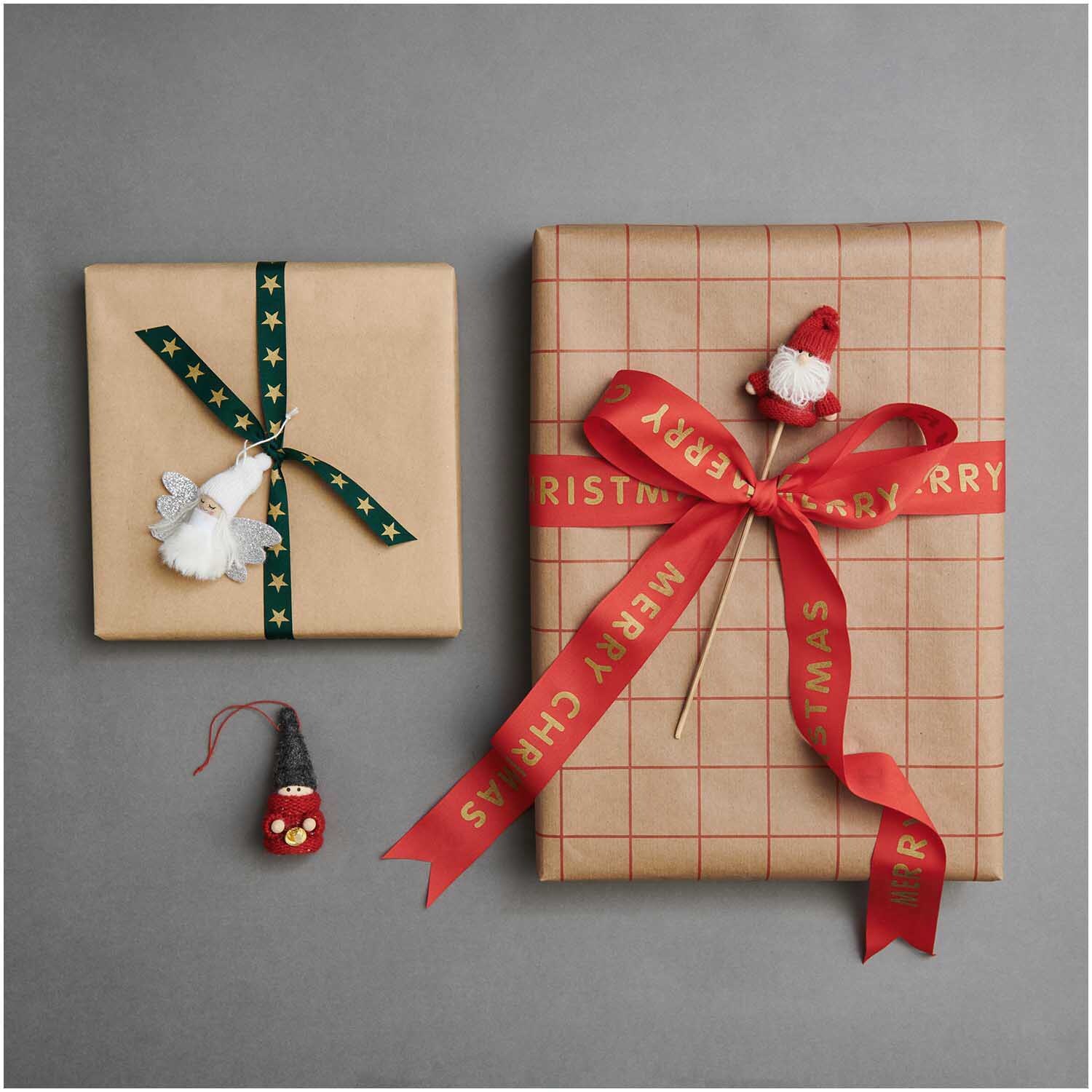 Paper Poetry Geschenkpapier mit Rastermuster, verpackt mit roten Schleifen und weihnachtlichen Dekorationen.