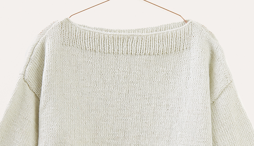 Strickanleitung Pullover aus Creative Cotton Fleece dk: Cremefarbener Pullover auf Bügel.