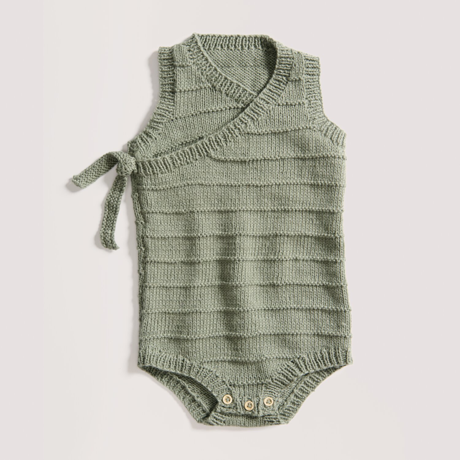 Strickset Strampler Modell 09 aus Baby 043 in Efeu. Weicher, ärmelloser Babybody mit Wickeloptik und seitlicher Schleife. Ideal für zarte Babyhaut.