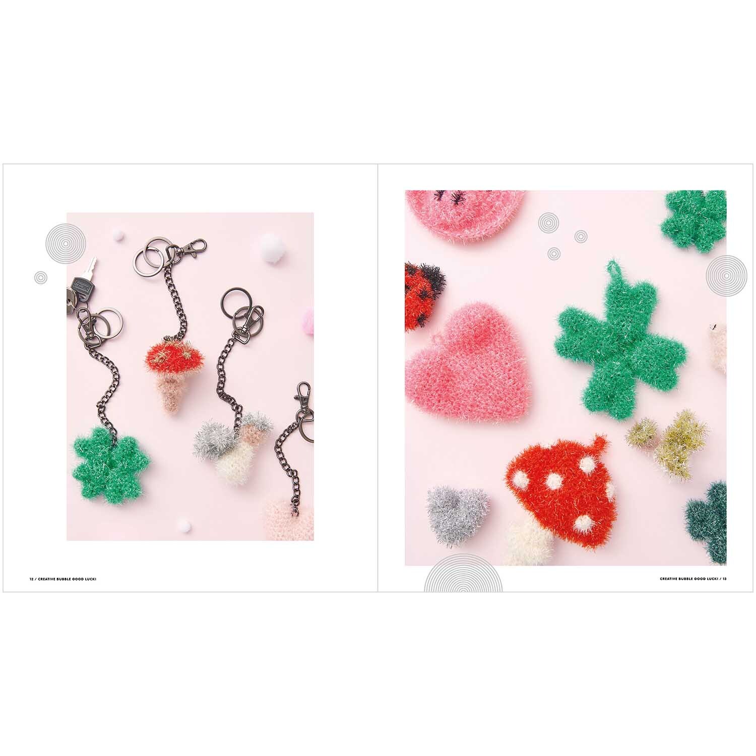Creative Bubble - Good Luck! zeigt bunte, flauschige Schlüsselanhänger in Kleeblatt- und Pilzform auf rosa Hintergrund.