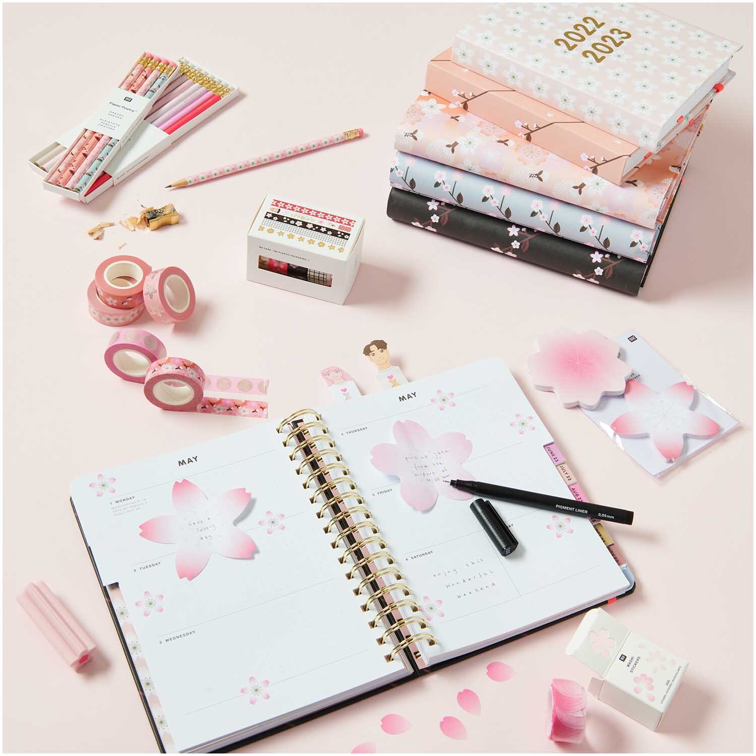 Paper Poetry Tape Set Kirschblüten: Ein Schreibtisch mit Notizbüchern, Kalender, Stiften und dekorativem Klebeband.